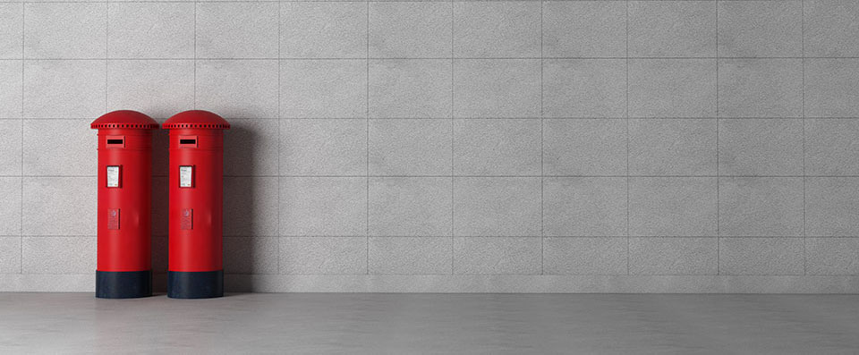 2 red post boxes side by side on a grey background