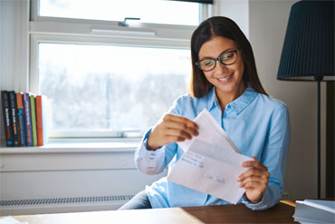 charity supporter opening mail at her desk