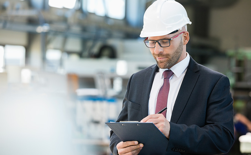 business man in hard hat looking at report