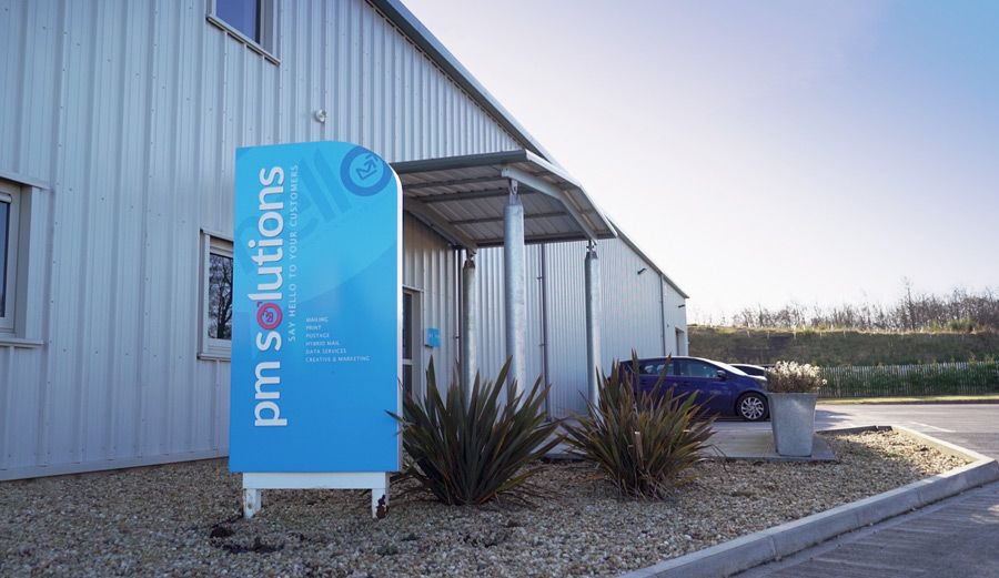 outside pm solutions new premises with the sign, entrance and parked cars