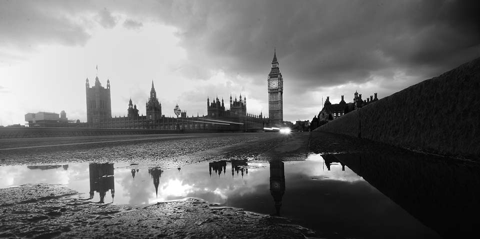 houses of parliament in london from low down on the thames river